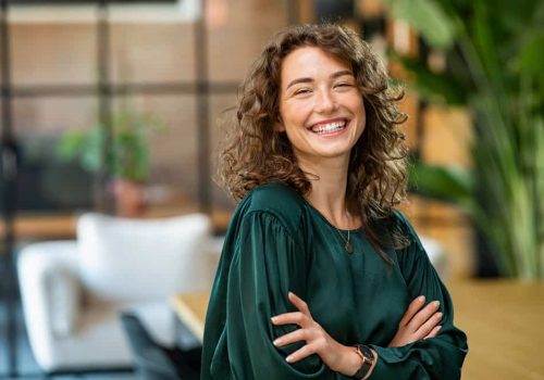 Portrait,Of,Young,Smiling,Woman,Looking,At,Camera,With,Crossed